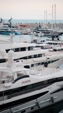Arka planda şehrin silueti olan Monaco Marina 'daki teknelerin görüntüsü. Dikey