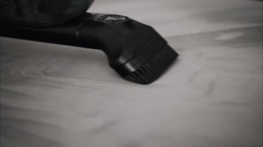 Gri bir kanepeyi temizleyen küçük bir süpürgeyi kapat.