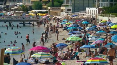 Juan-les-Pins, Fransa - 14 Ağustos 2024: İnsanlar denizde yüzüyor ve plajda dinleniyorlar