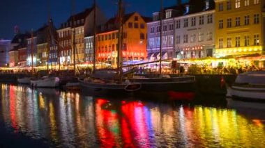 Kopenhag, Danimarka - 18 Ekim 2024: Nyhavn ilçesinin Gece Zamanlaması kanal suyunda renkli yansımalarla