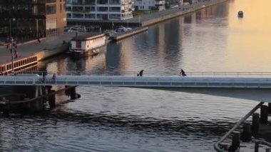 Kopenhag, Danimarka 'daki Quay Köprüsü' nde hareket eden insanların insansız hava aracı görüntüsü.