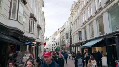 Kopenhag, Danimarka - 24 Ekim 2024: Şehir merkezindeki Stroget alışveriş caddesinin girişindeki insanlar