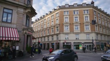 Kopenhag, Danimarka - 24 Ekim 2024: Arabalar ve insanlar gündüz Kongens Nytorv Plaza 'sında ilerliyorlar