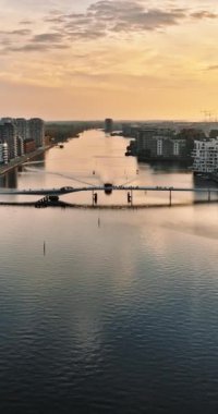 Danimarka 'nın Kopenhag limanındaki Quay Köprüsü' nün hava aracı görüntüsü gün batımında. Dikey