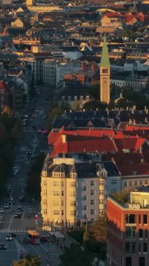 Danimarka, Kopenhag 'daki Vesterbro bölgesinin hava aracı görüntüsü gün batımında. Dikey