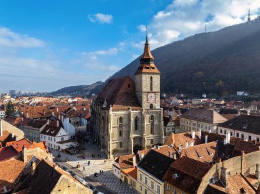 Brasov 'daki Black Church' ün sonbahar mevsiminde eski merkez hava aracı görüntüsü. Dağlar ve bulutlu mavi gökyüzü. Romanya