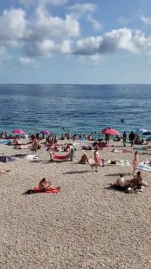 Güzel, Fransa - 7 Ekim 2024: güneşli bir günde insanlar plajda dinleniyor. Dikey