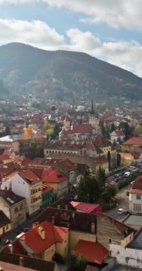 Romanya 'nın güneydoğu Transilvanya kentindeki Brasov kentinin hava aracı görüntüsü dağlarla çevrili. Dikey. Dikey