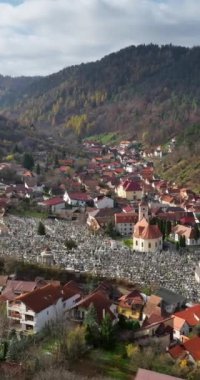 Romanya 'nın Brasov kentindeki bir mezarlığın yakınındaki St. Nicholas Kilisesi' nin insansız hava aracı görüntüsü. Dikey