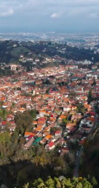 Romanya 'nın güneydoğu Transilvanya kentindeki Brasov kentinin hava aracı manzarası dağlarla çevrili. Dikey