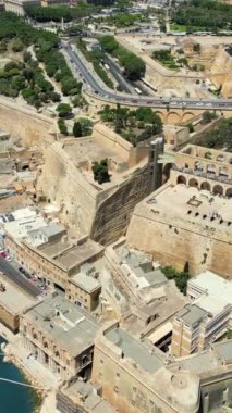 Malta 'nın Valletta kentinin hava aracı görüntüsü, gün ışığında Akdeniz ile çevrili. Dikey