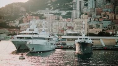Monaco Marina 'ya kenetlenmiş teknelerin görüntüsü ve arka planda şehrin silüeti.