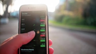 Monte Carlo, Monaco - 4 Ekim 2024: Hisse senedi fiyatlarını gösteren bir mali izleme uygulaması açan bir adama yakın çekim