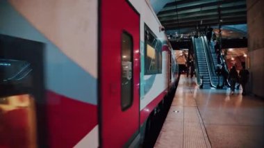 Monte Carlo, Monako - 4 Ekim 2024: İnsanlar ve trenler Monako tren istasyonunda parlak ışıklarla ilerliyorlar