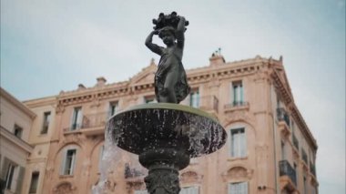 Fransa, Cannes 'ın arka planına sahip bir çeşmeye su dökülüyor