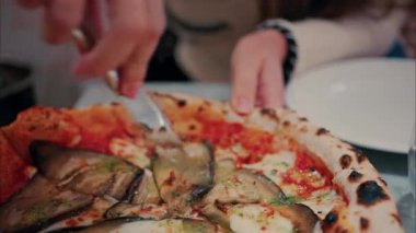 Patlıcanla pizza doğrayan ve restoranda yiyen bir kadının fotoğrafını çek.