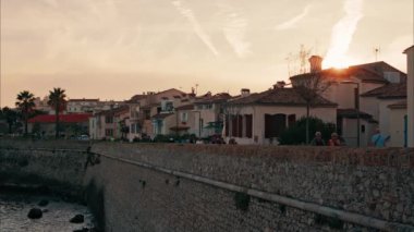 İnsanlar gün batımında Antibes, Fransa 'da yürüyorlar.