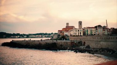 İnsanlar gün batımında Antibes, Fransa 'da yürüyorlar.