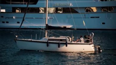 Golfe-Juan, Fransa - 8 Ekim 2024: Golfe-Juan Limanı 'na yanaşmış gemilerin yanından geçen beyaz tekne