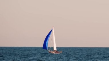 Fransa, Golfe-Juan 'da mavi yelkenli küçük bir gemi.