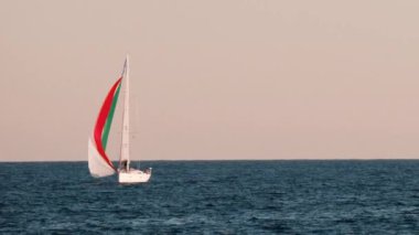 Fransa 'nın Golfe-Juan şehrinde kırmızı yelkenli taşıyan küçük bir gemi.