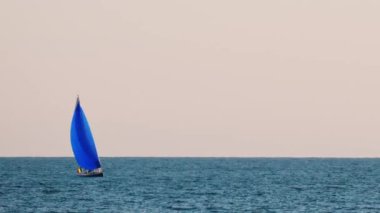 Fransa, Golfe-Juan 'da mavi yelkenli küçük bir gemi.