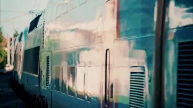 Fransa 'da bir istasyonun yakınındaki raylarda ilerleyen mavi bir trenin önünü kapatın.