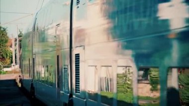 Fransa 'da bir istasyonun yakınındaki raylarda ilerleyen mavi bir trenin önünü kapatın.