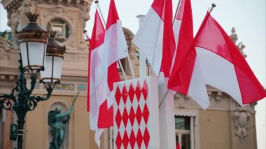 Monte Carlo, Monako - 24 Ekim 2024 Monako arması ve Monte Carlo Kumarhanesi önünde birden fazla bayrak sallanıyor.