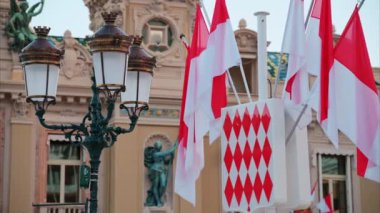 Monte Carlo, Monako - 24 Ekim 2024 Monako arması ve Monte Carlo Kumarhanesi önünde birden fazla bayrak sallanıyor.