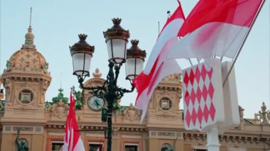 Monte Carlo, Monako - 24 Ekim 2024 Monako arması ve Monte Carlo Kumarhanesi önünde birden fazla bayrak sallanıyor.