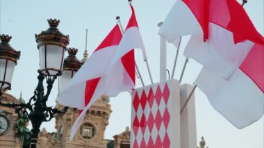 Monte Carlo, Monako - 24 Ekim 2024 Monako arması ve Monte Carlo Kumarhanesi önünde birden fazla bayrak sallanıyor.