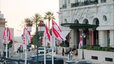 Monte Carlo, Monako - 24 Ekim 2024 Monako arması ve Monte Carlo Kumarhanesi önünde birden fazla bayrak sallanıyor.