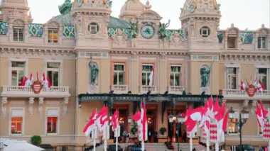 Monte Carlo, Monako - 24 Ekim 2024 Monako arması ve Monte Carlo Kumarhanesi önünde birden fazla bayrak sallanıyor.
