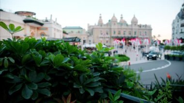 Monte Carlo Kumarhanesi 'nin önünde sallanan birden fazla Monegasque bayraklarının uzak, bulanık sokak görüntüsü