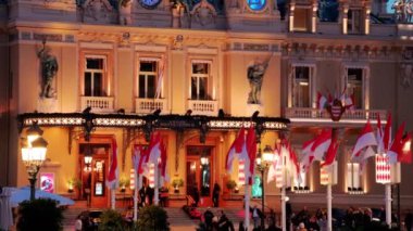 Monte Carlo, Monako - 24 Ekim 2024 Monako arması ve Monte Carlo Kumarhanesi önünde sallanan birden fazla bayrak