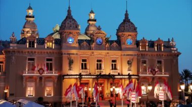 Monte Carlo, Monako - 24 Ekim 2024 Monako arması ve Monte Carlo Kumarhanesi önünde sallanan birden fazla bayrak
