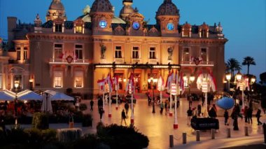 Monte Carlo, Monaco - 24 Ekim 2024: Monte Carlo Kumarhanesi önünde sallanan birden fazla Monegasque bayraklarının sokak görüntüsü