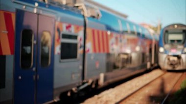 Fransa 'da bir istasyonun yakınındaki raylardan geçen iki mavi treni kapatın.