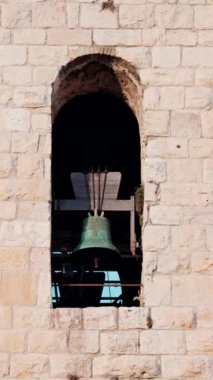 Bir kulede asılı duran büyük, yeşil bir çana yaklaş. Dikey