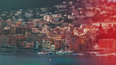 Fransa 'nın Villefranche sur Mer limanındaki küçük, ahşap teknelerin arka planında şehrin manzarası var.