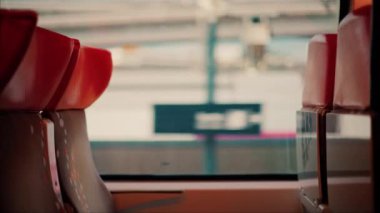 Bulanık manzaralı hareket halindeki trenin penceresinin yanındaki koltukları kapat.