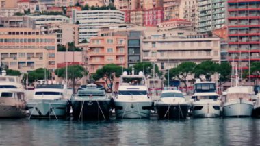 Monaco Marina 'ya kenetlenmiş teknelerin görüntüsü ve arka planda şehrin silüeti.