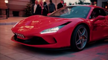 Monte Carlo, Monaco - 24 Ekim 2024: Kırmızı Ferrari arabası Monte Carlo Kumarhanesi 'nin avlusunda ilerliyor.