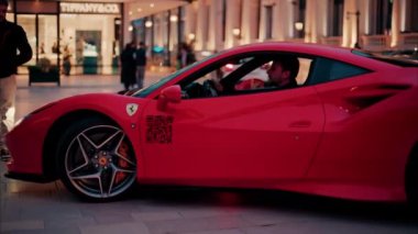 Monte Carlo, Monaco - 24 Ekim 2024: Kırmızı Ferrari arabası Monte Carlo Kumarhanesi 'nin avlusunda ilerliyor.