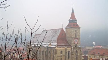 Romanya 'nın güneydoğu Transilvanya kentindeki Brasov kentindeki Siyah Kilise' nin uzaktan görüşü kar yağarken