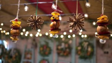 Tarçın ve portakaldan yapılmış Noel süslemelerini kapatın. Arka planda bulanık bir ipten sarkıyor.
