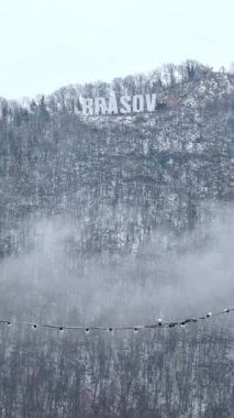 Brasov karda Tampa dağının tepesinde yazıyor. Dikey