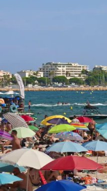 Cannes, Fransa - 15 Ekim 2024: İnsanlar sahilde yüzüyor ve dinleniyor. Dikey