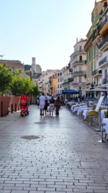 Cannes, Fransa - 15 Ekim 2024: İnsanlar gün ışığında şehrin sokaklarında yürüyor. Dikey
